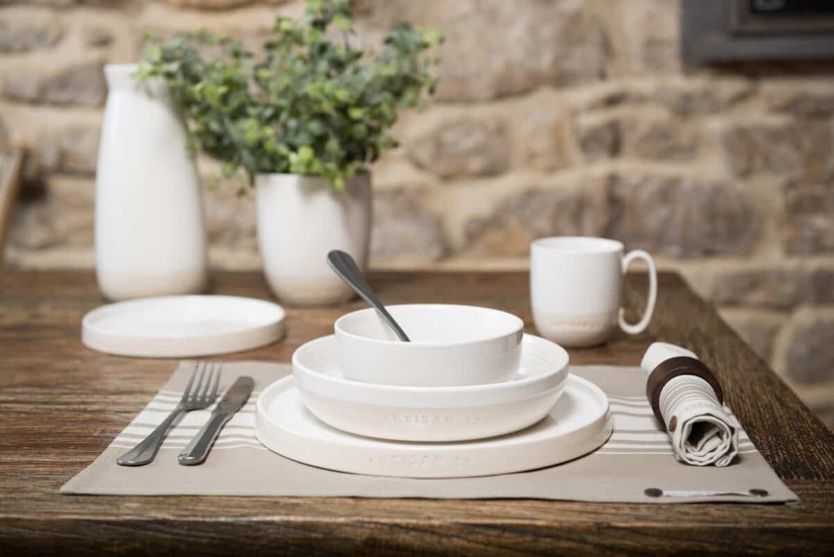 a dinner place with plate, pasta bowl and small bowl.