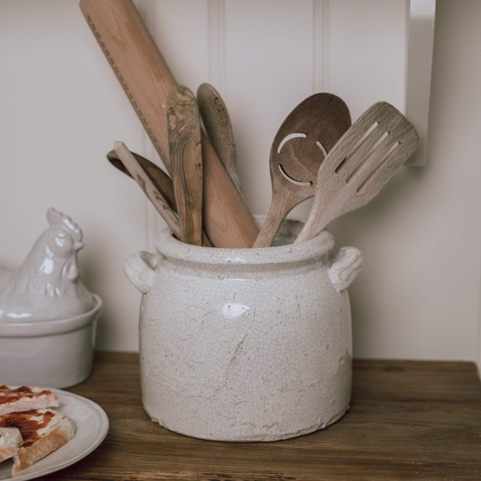 Belle Ceramic Utensil Holder on wooden chopping board with wooden utensils.