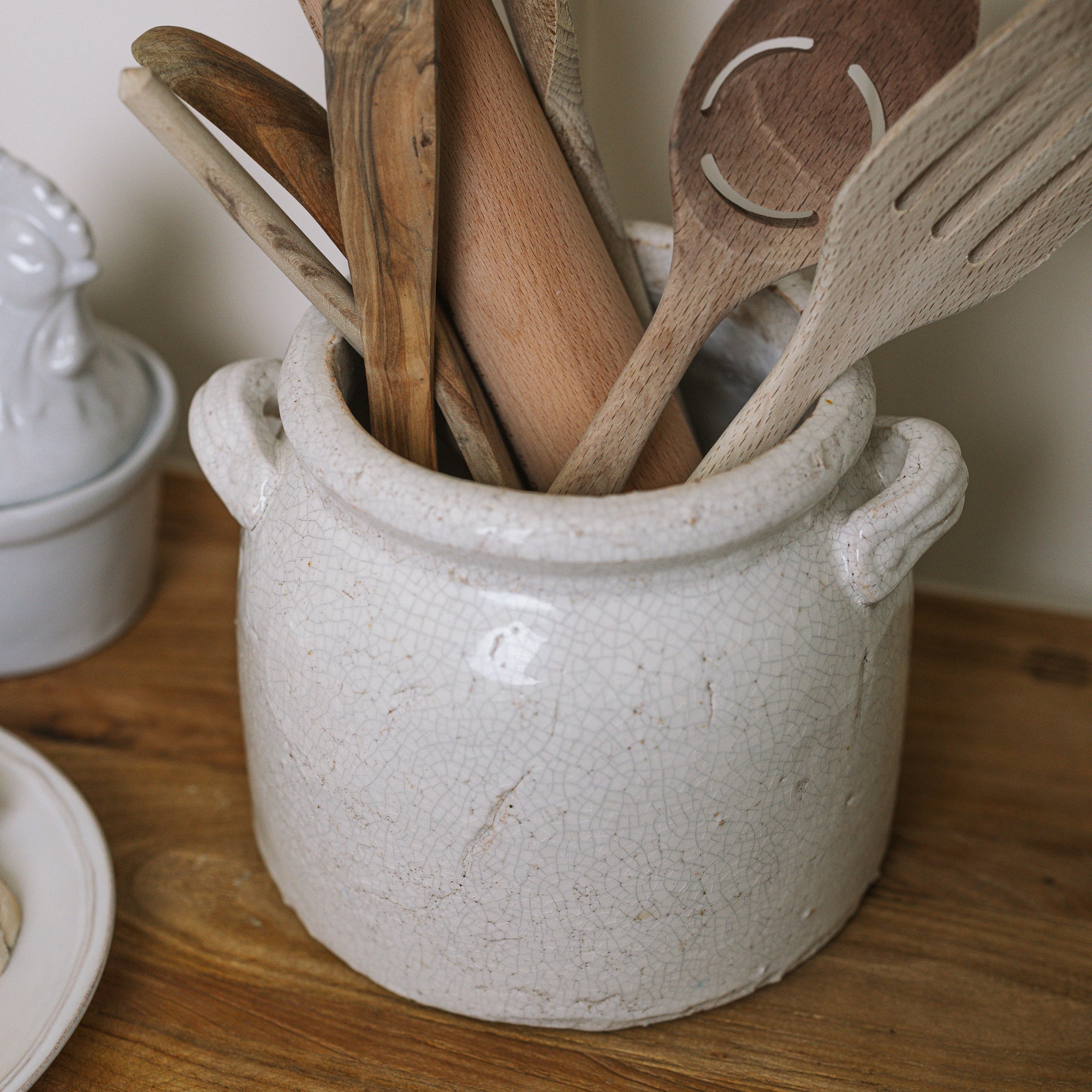 Belle Ceramic Utensil Holder on wooden chopping board with wooden utensils.