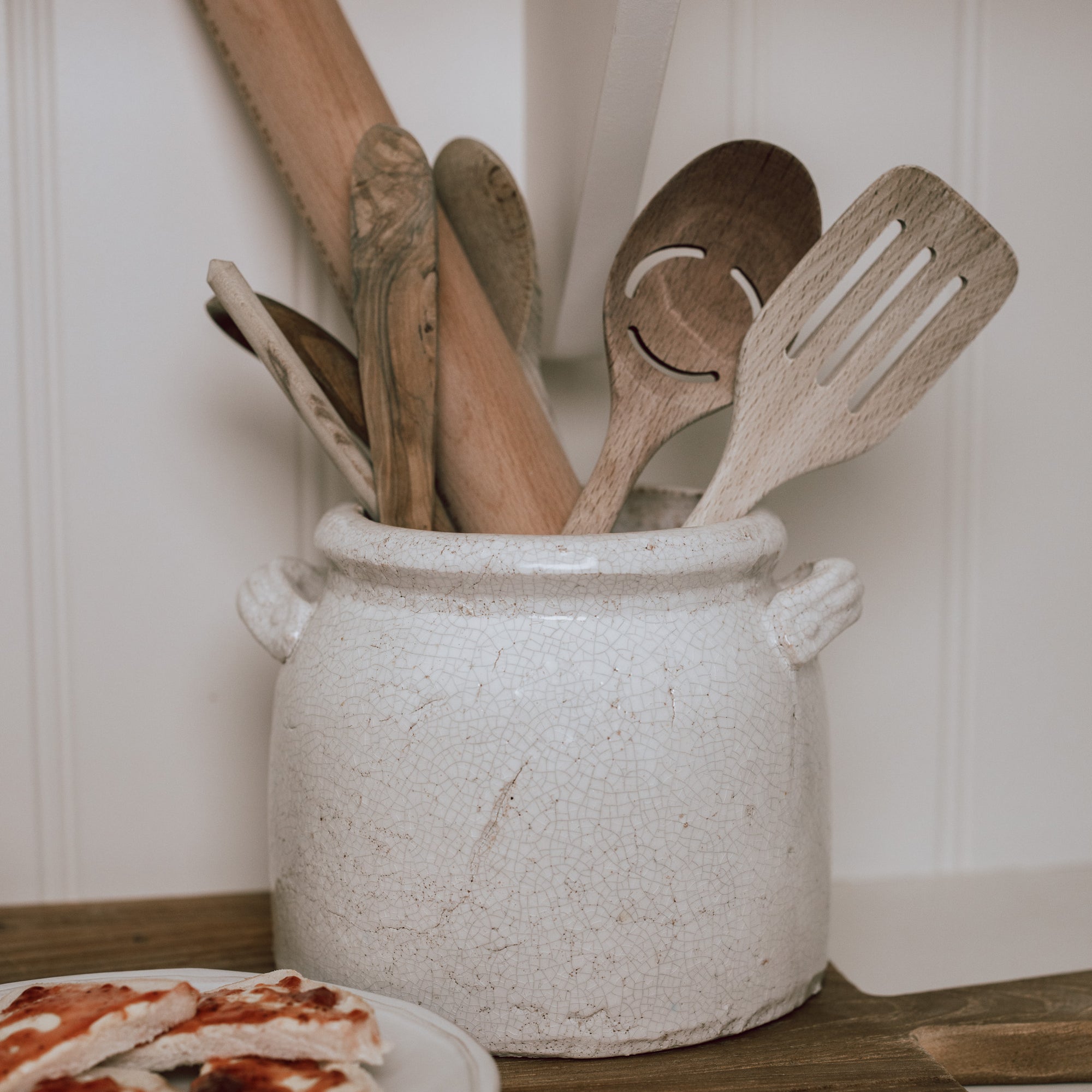 Belle Ceramic Utensil Holder on wooden chopping board with wooden utensils.