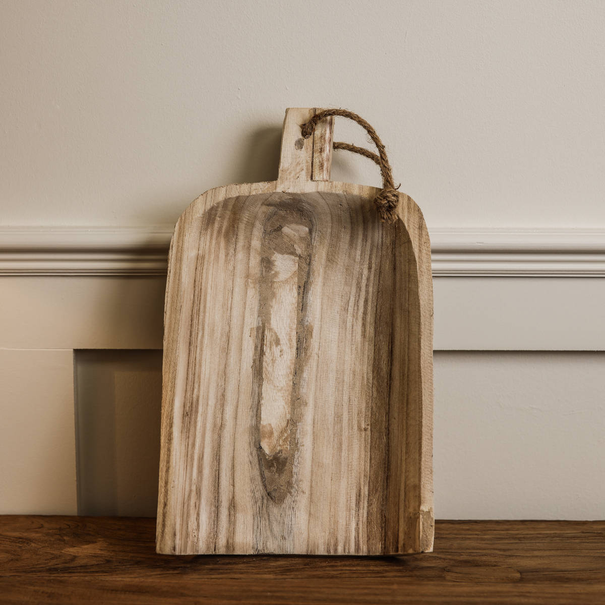 Small wooden tray balanced up against a wall.