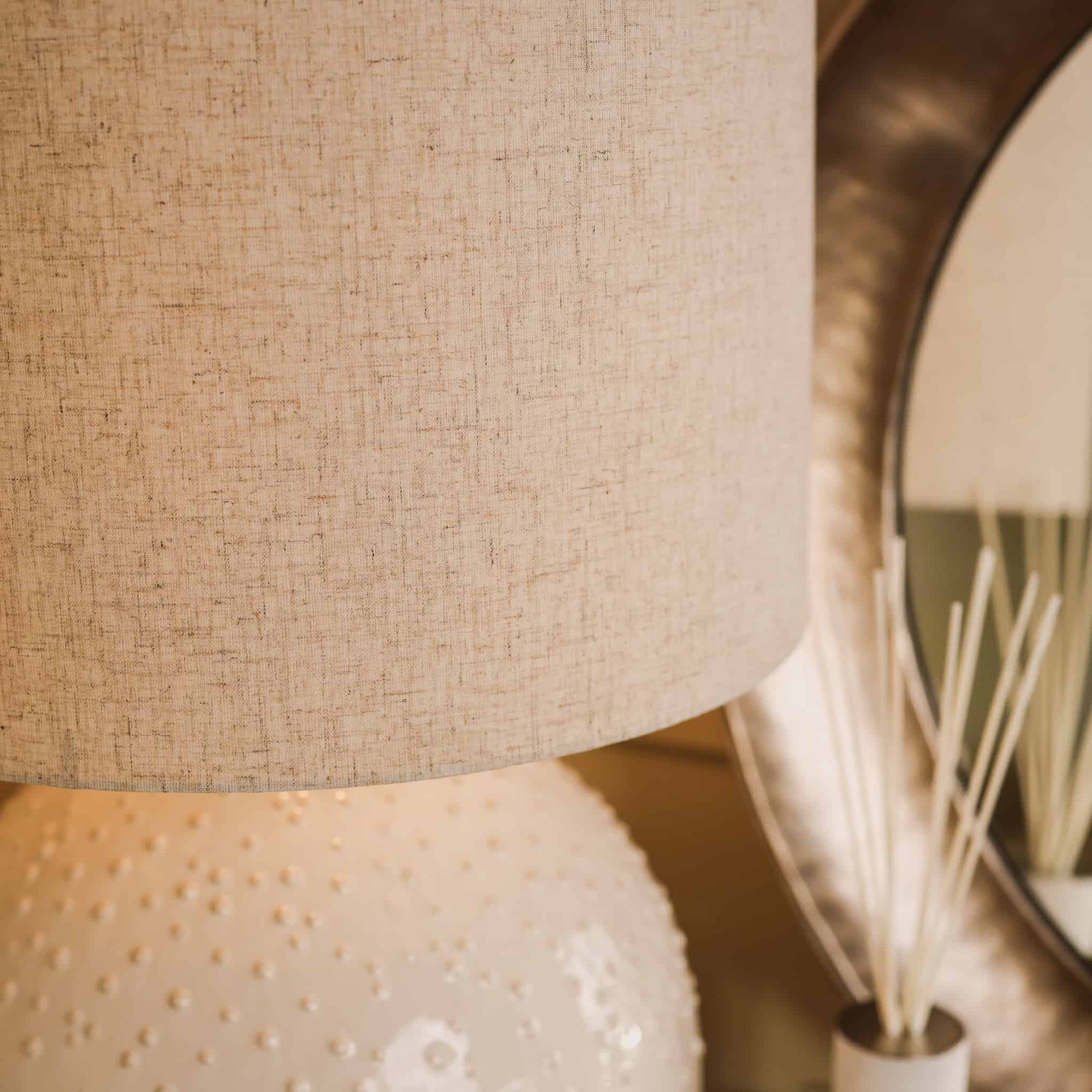 Close up of white textured ceramic table lamp and shade.