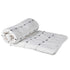 Black and white cotton bedspread with tassels, rolled up.
