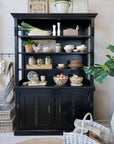 Black shelving unit filled with kitchen crockery, pantry items and farmhouse accessories.