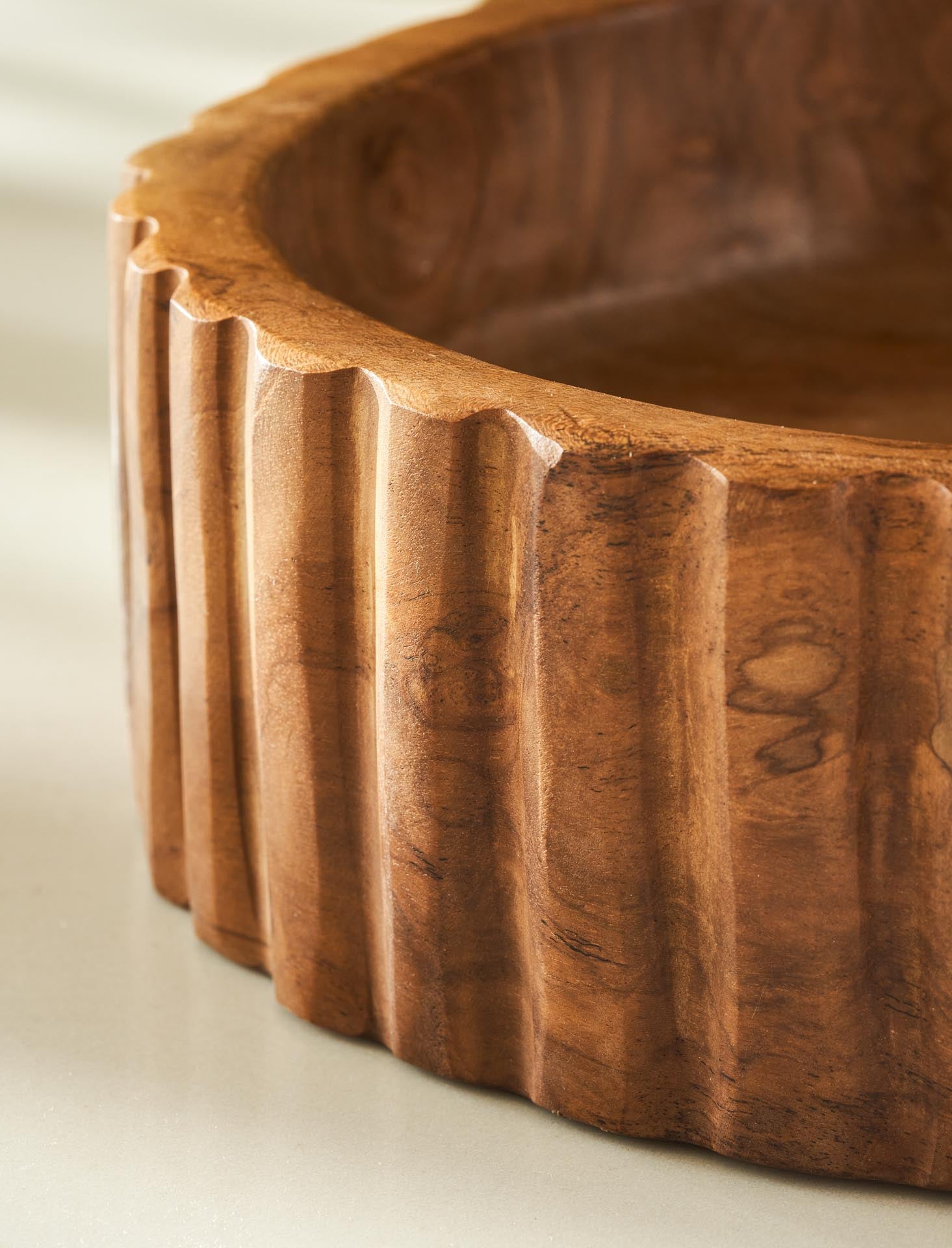 Wooden bowl with textured rim on a light background