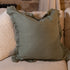 Large green ruffle linen cushion on cream sofa.
