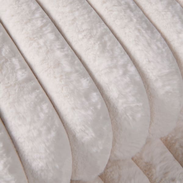 Close up of cream faux fur throw.