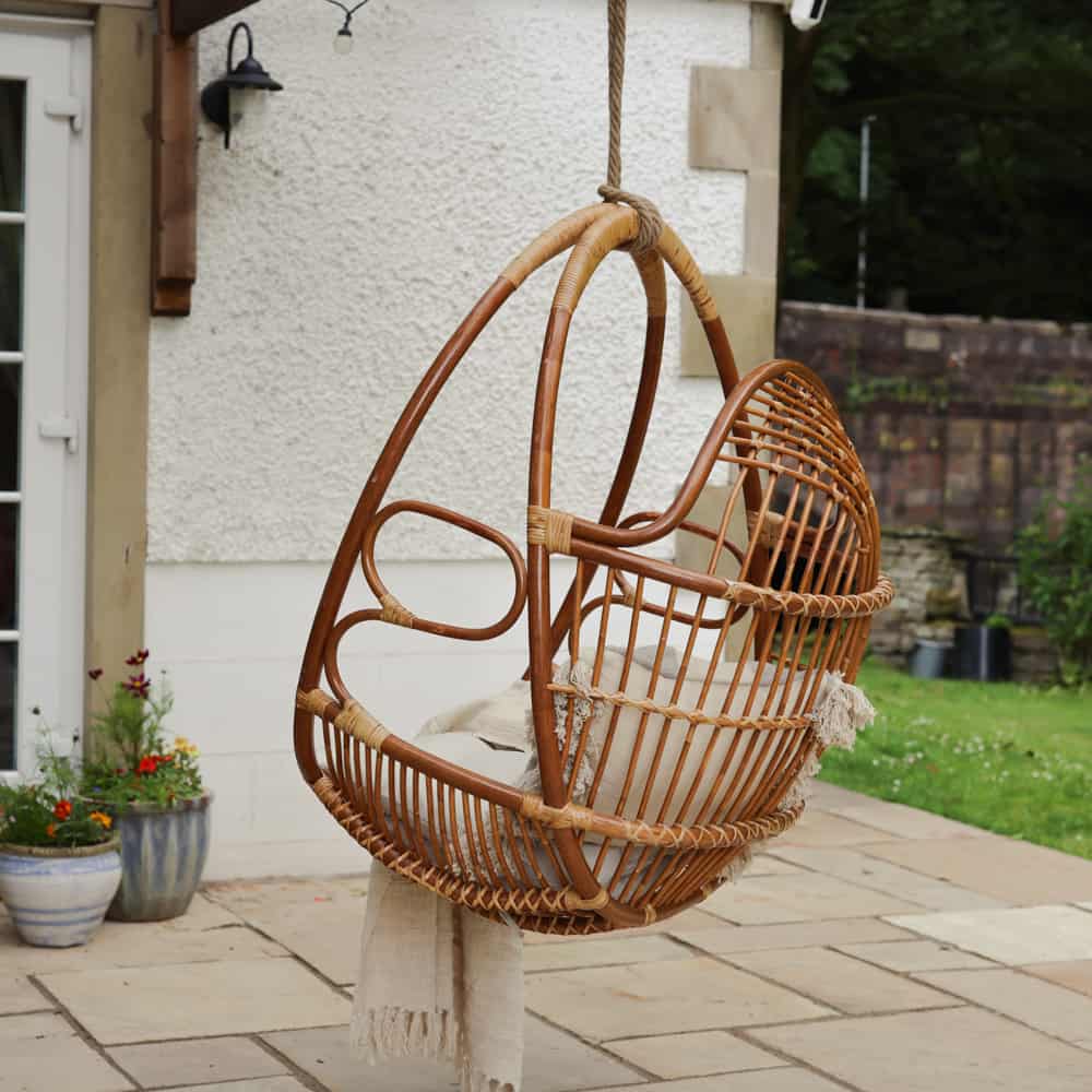 Hanging swinging egg chair in the garden from the back.