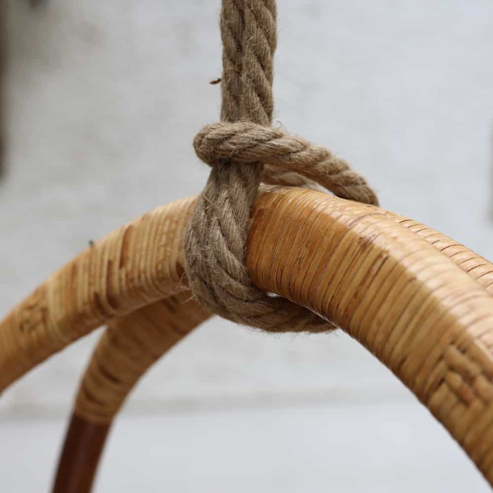 Close up of rope and woven top on rattan hanging egg swing chair.