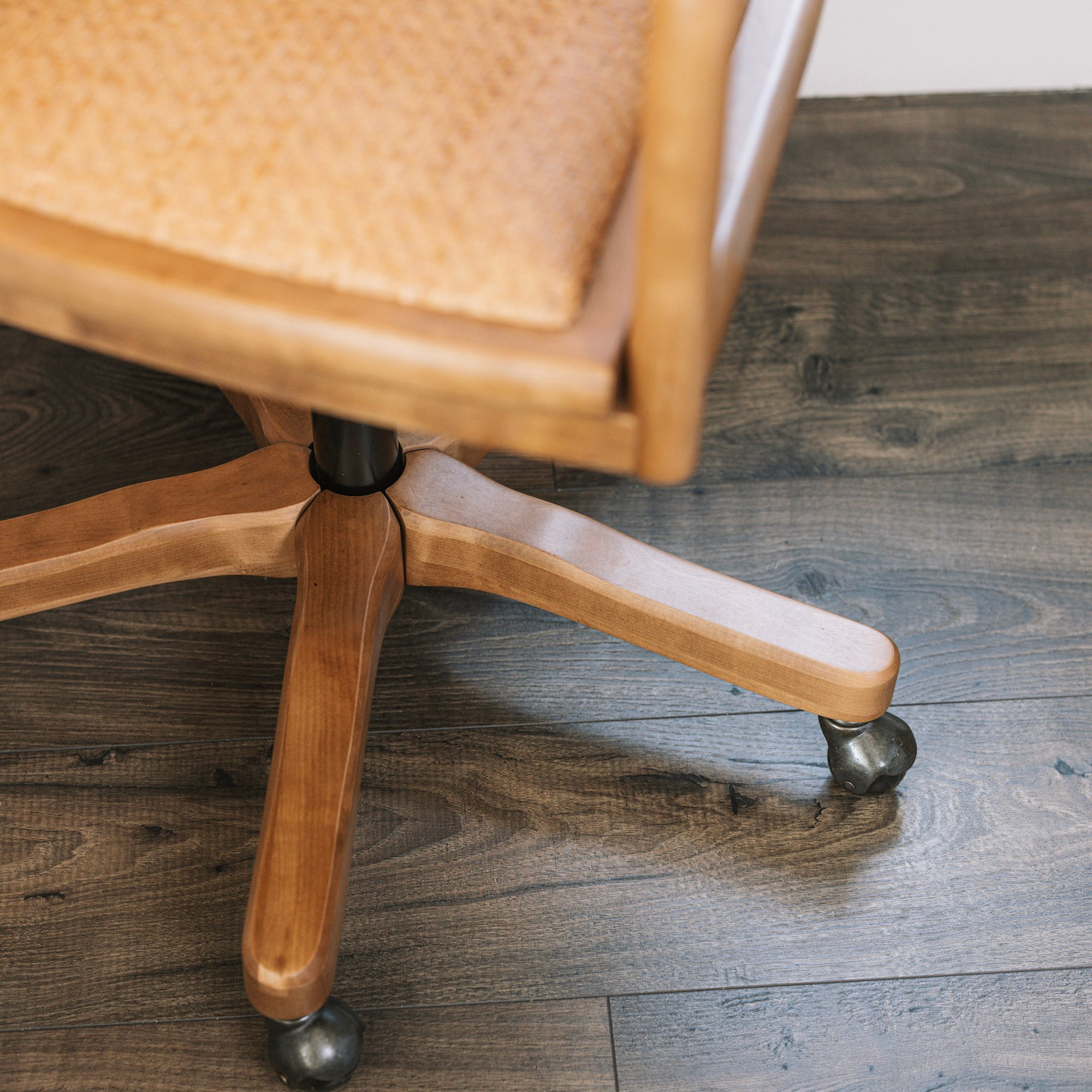 Natural rattan wicker office chair with neutral cushion at white desk.