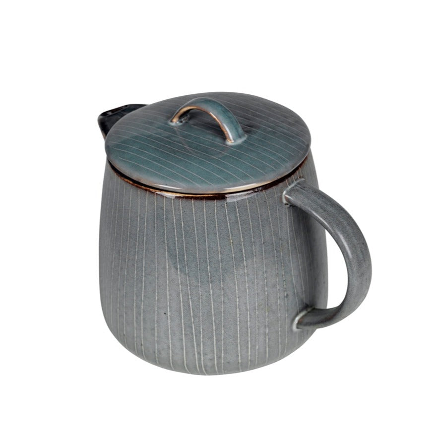 Blue glazed tea pot with stripes and handle lid, view from handle.