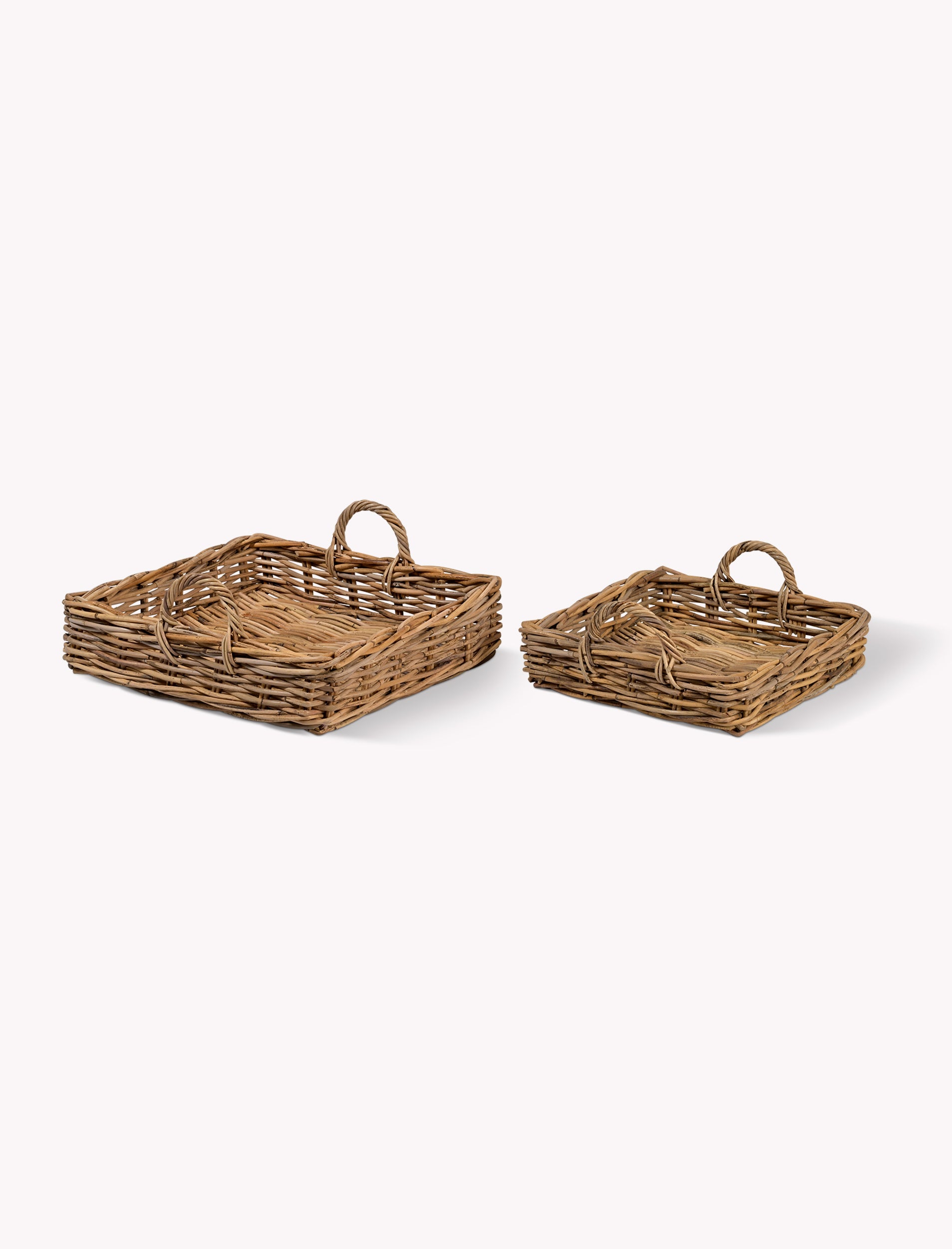 Two natural woven trays on a white background
