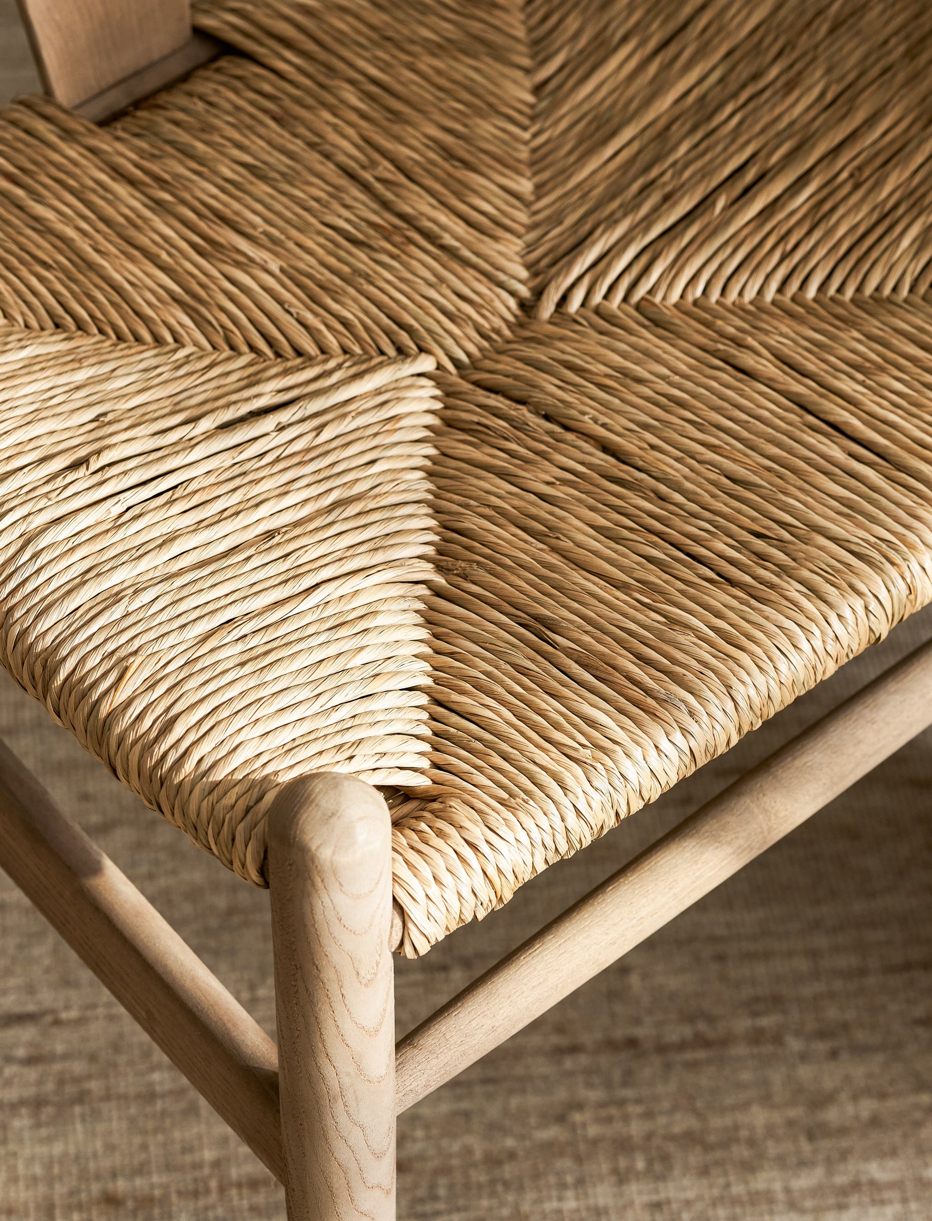 Close-up of a woven wishbone dining chairs with natural wood frame