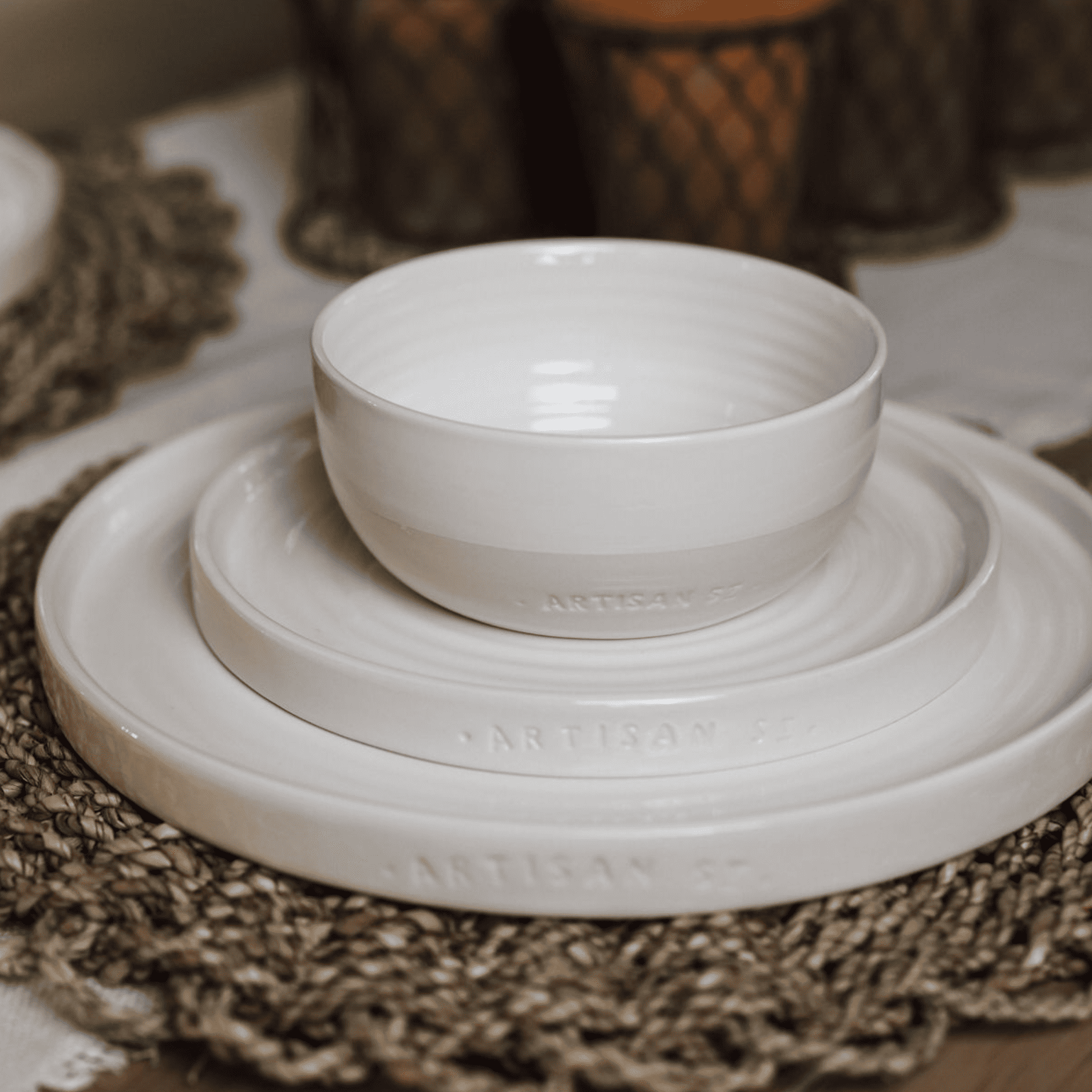 Set of cream crockery on a wicker place mat.