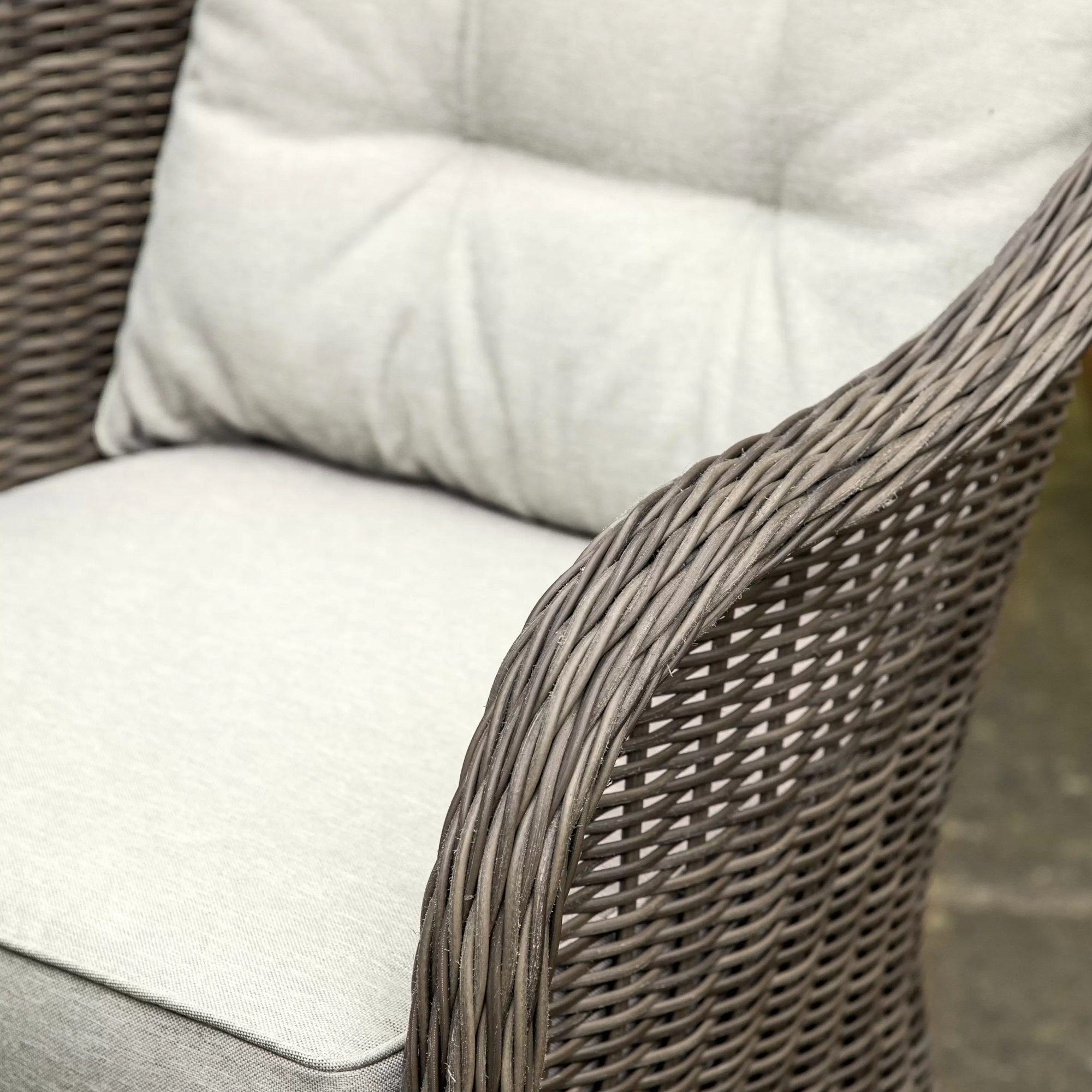 Close up image of a shower proof cushion on rattan chair.