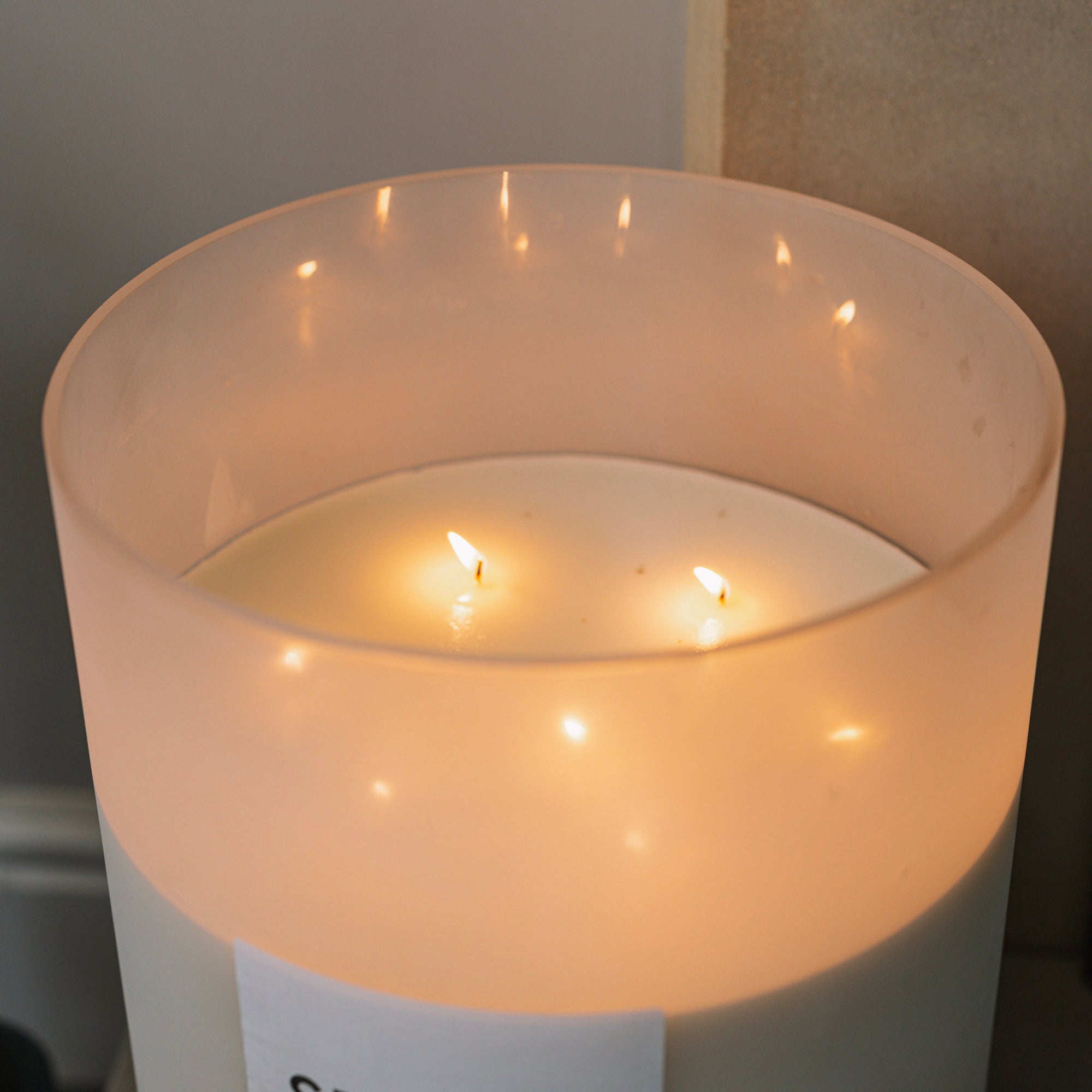 Sences alang alang white giant candle shot from above on stone fireplace.