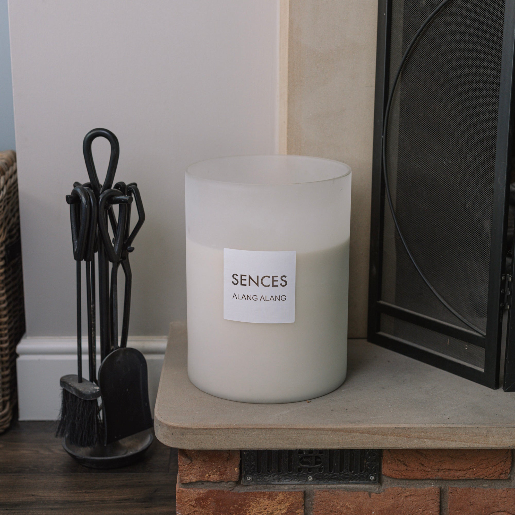 Sences alang alang white giant candle shot from above on stone fireplace.