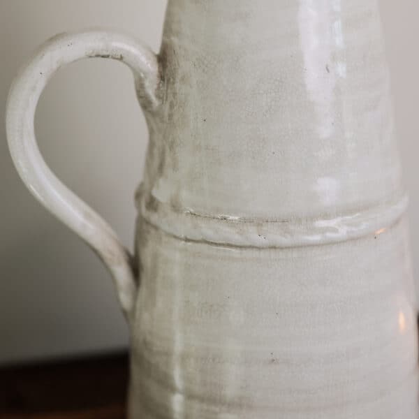 A vintage style stone jug with handle.