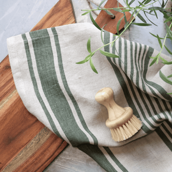 Green striped tea towel on a wooden chopping board