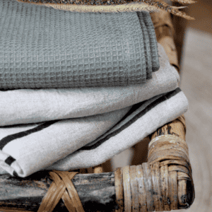 Pile of linen tea towels on a rustic wooden chair