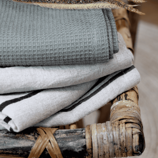 Pile of linen tea towels on a rustic wooden chair