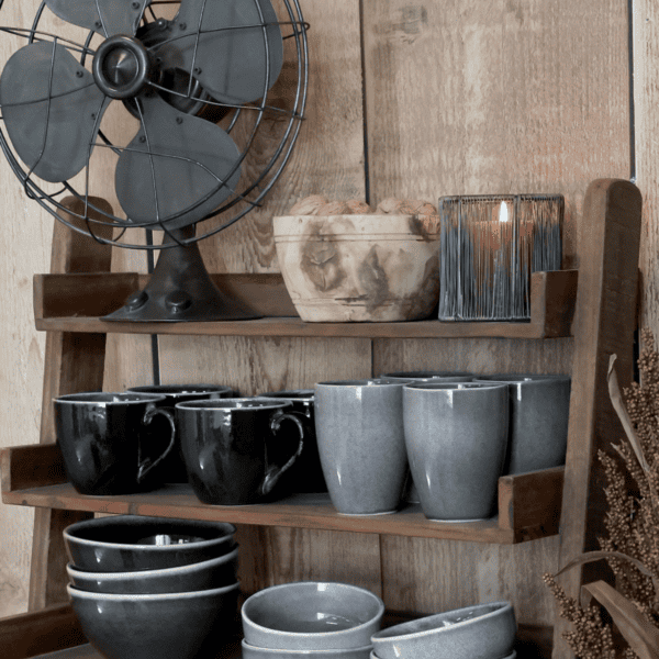 wooden kitchen shelf with grey and black pottery.