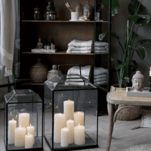 Two black and glass lanterns filled with pillar candles.
