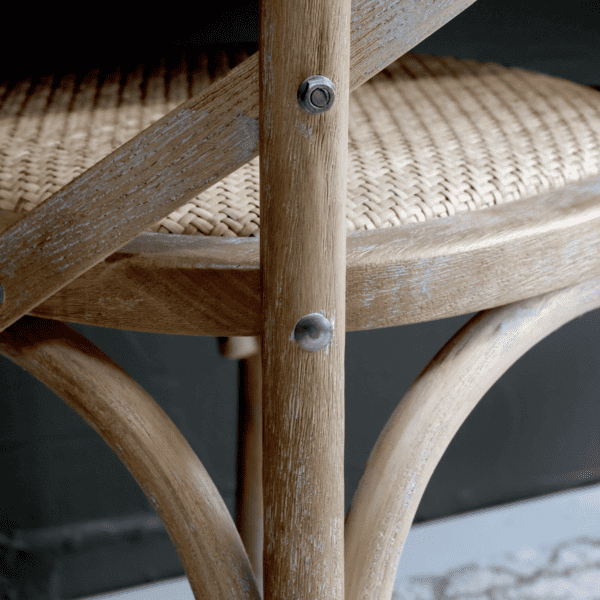 Fixing details on the wooden french style dining chair with wicker seat.