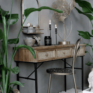 A wooden desk with candles and plants.
