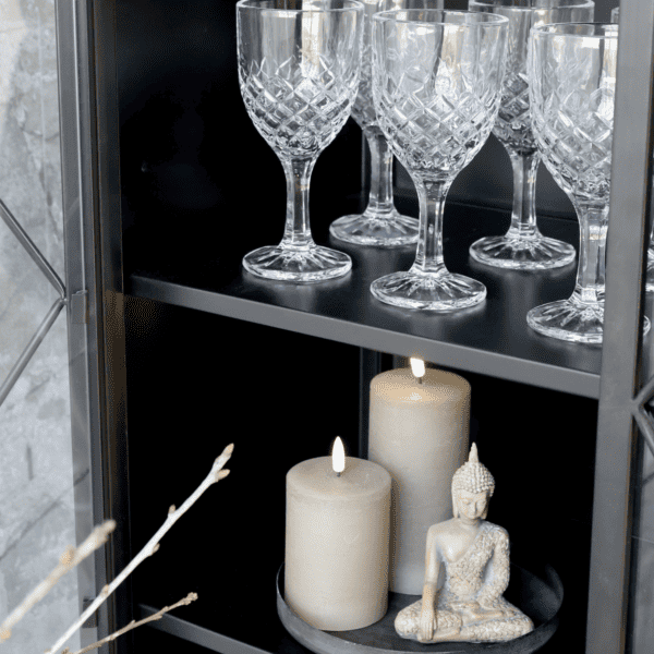 Black iron shelf with crystal glassware and candles.