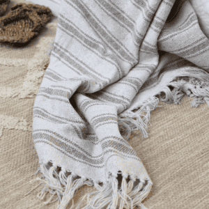 Chic Antique Grain Sack Throw in Latte on a rattan rug
