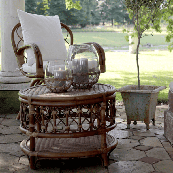 Chic Antique Glass & Wicker Hurricane Candle Holder outside with armchair and olive tree