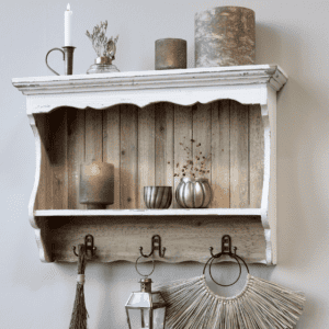 Antique cream wall shelf with brass home decor and candles.
