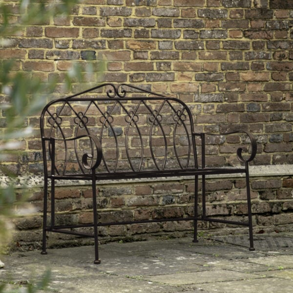 With a chic country style, this bench is perfect for sitting and enjoying the sun. Crafted from metal with a deep metal patina finish, the bench's sweet design details make it a beautiful addition to any garden.