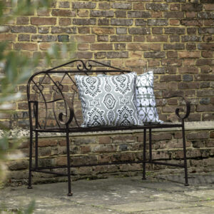 With a chic country style, this bench is perfect for sitting and enjoying the sun. Crafted from metal with a deep metal patina finish, the bench's sweet design details make it a beautiful addition to any garden.