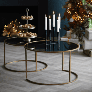 Duarte Set of Two Antique Gold Smoked Glass Coffee Table with candles on and fairy lights in background