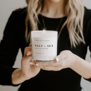 Salt And Sea Soy Candle In White Jar Shoot Image In Hands