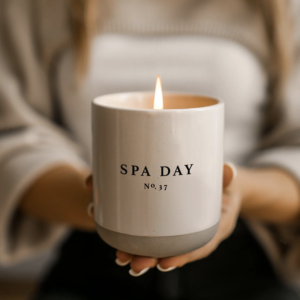 Sweet Water Decor Spa Day Soy Candle In Stoneware Jar Held Up and Lit