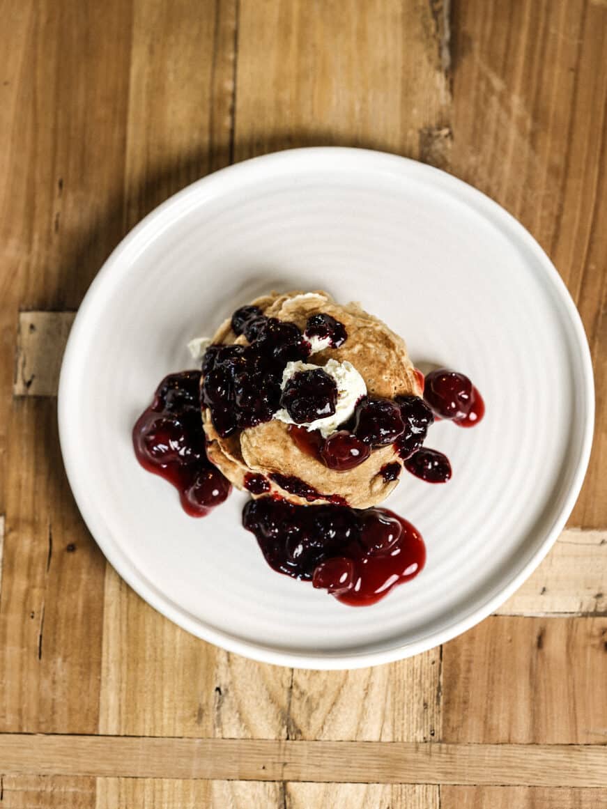 Stack of pancakes with berry syrup and mascarpone