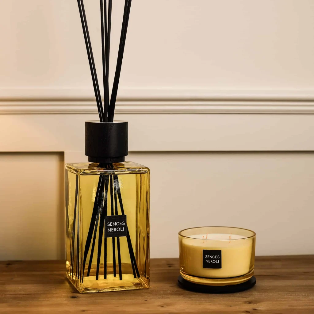 Yellow soy wax candle and large diffuser on wooden console.