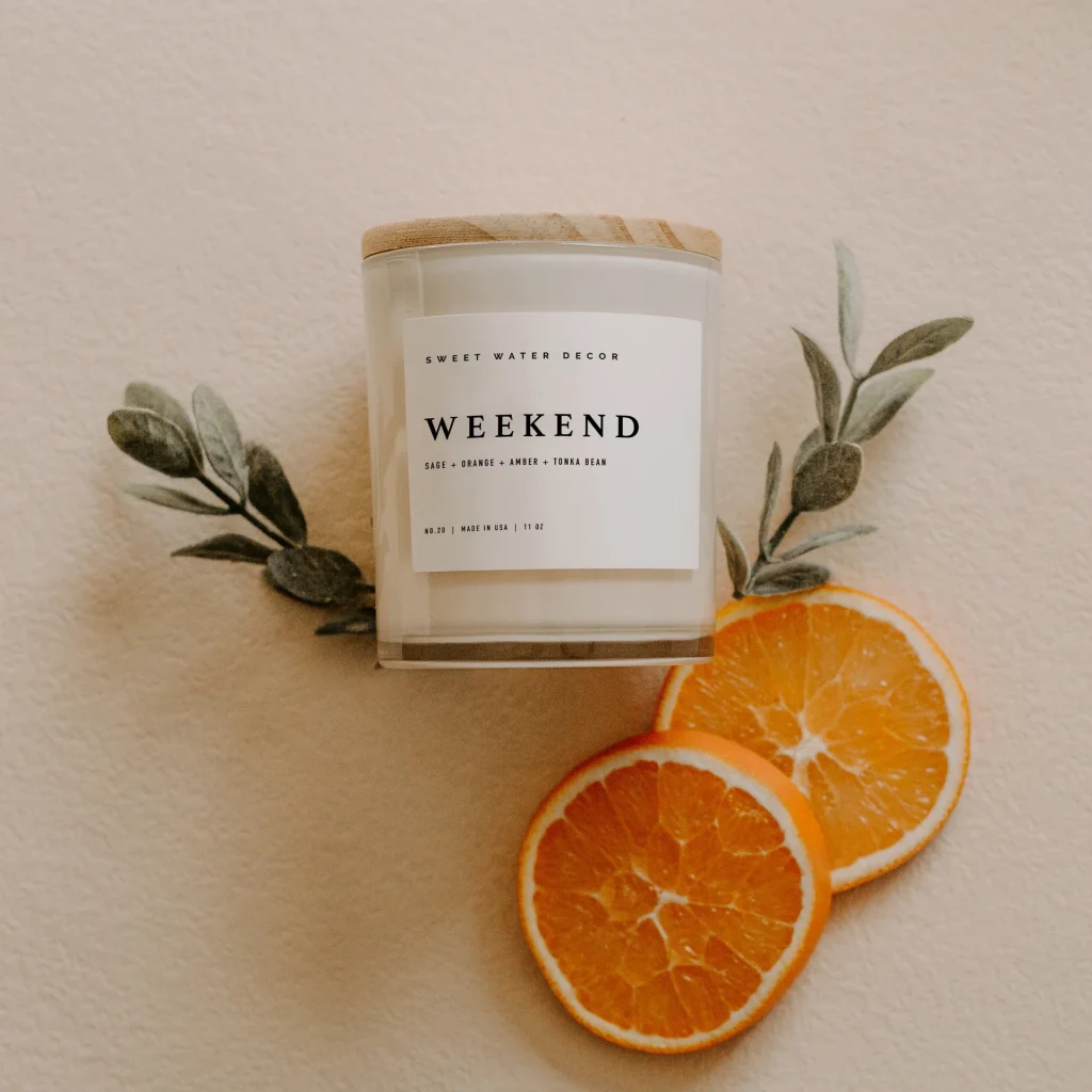 White soy wax candle with oranges and herbs.